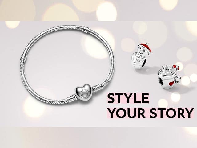 Zilveren armband met hartsluiting en twee bedels naast tekst STYLE YOUR STORY.