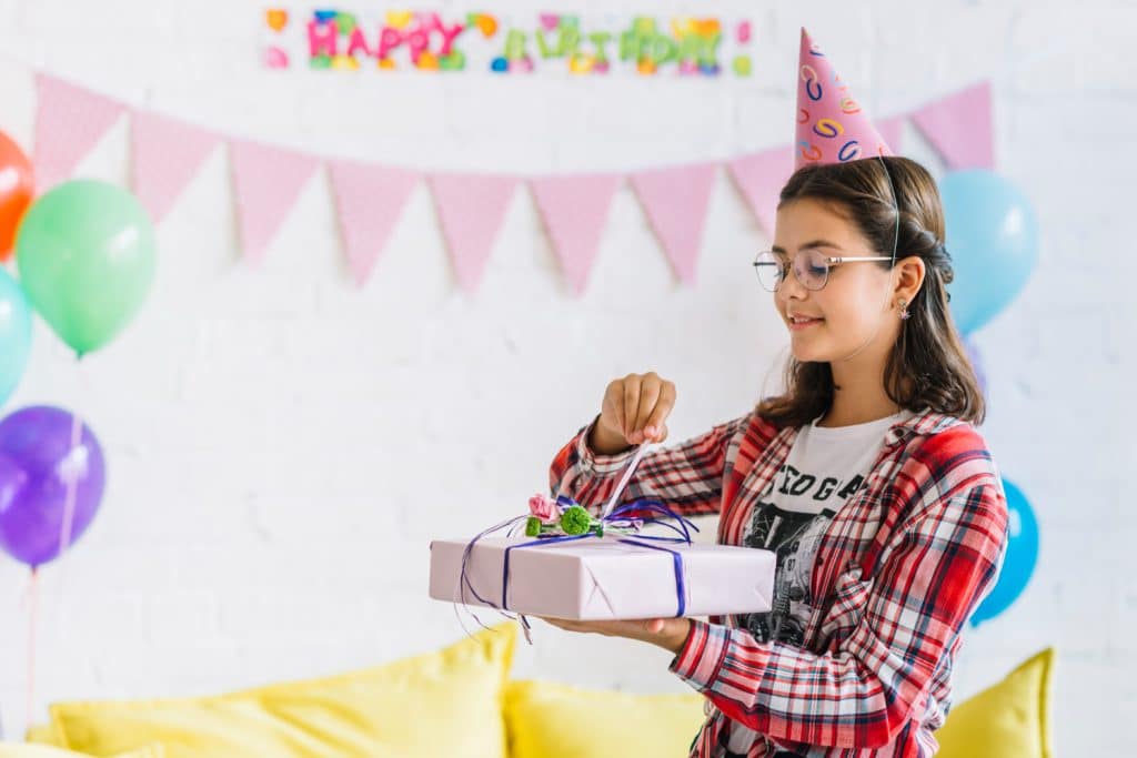 girl unwrapping birthday gift